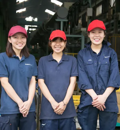 本社工場の玄関前にいる女性社員のグループ写真